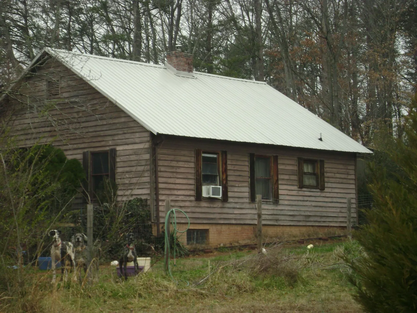 White metal roof on an old wood sided farmhouse, from a Metal Roof Installation job in Weldon